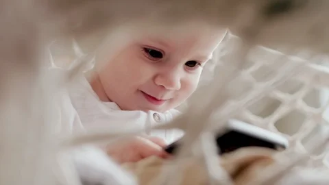 Kid in Wicker Chair Using Smartphone Vidéo 101040368