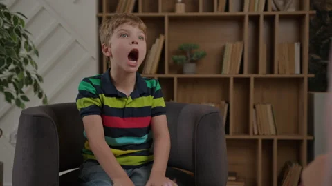 Kid working with speech therapist sitting on armchair in therapist office Stock Footage 219799521