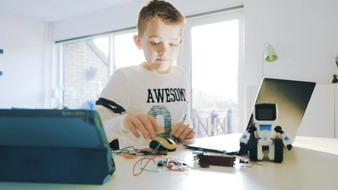 Kid works with science project in front of laptop and starts to type on keyboard Stock Footage 102174709