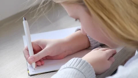 Kid writing in notebook at home Stock Footage 169454452