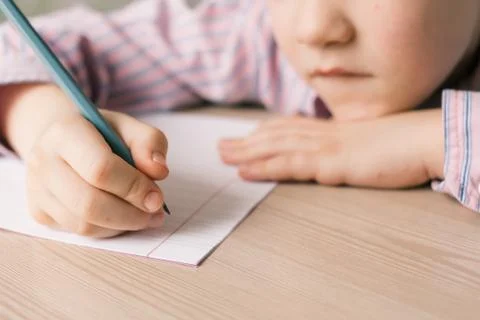 Kid writing in notebook. Stock Photos
