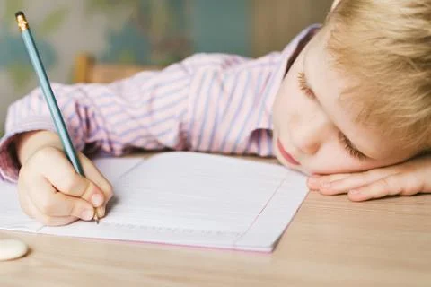 Kid writing in notebook Stock Photos