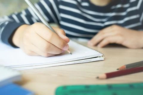 Kid writing in notebook. Stock Photos
