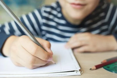 Kid writing in notebook. Stock Photos