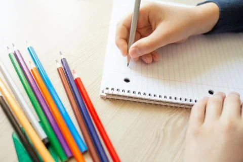 Kid writing in notebook. Stock Photos