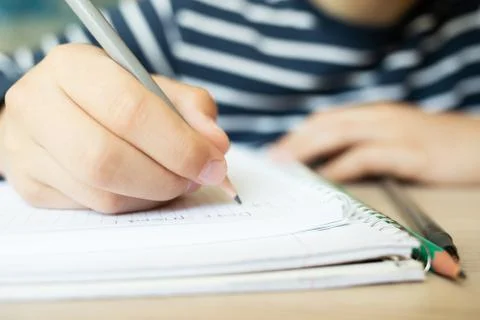 Kid writing in notebook. Stock Photos