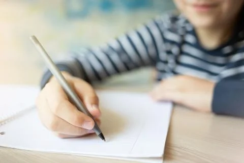 Kid writing in notebook. Stock Photos