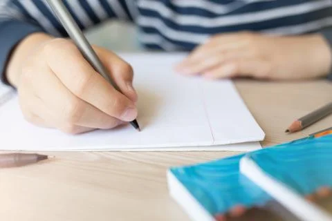 Kid writing in notebook. Stock Photos