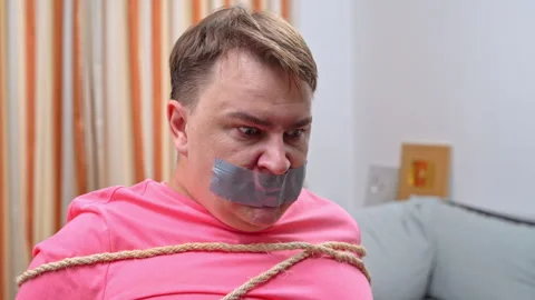 Kidnapped hostage bound man trying to get out of captivity Stock Footage 262395756