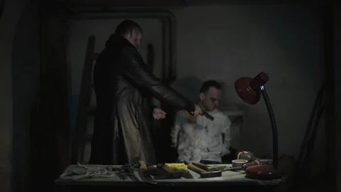 Kidnapper killer puts pistol on head of tied victim and shoots, man killing man. Stock Footage 86255824