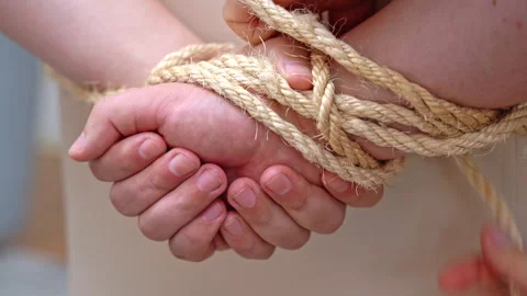 Kidnapper secures hands of hostage behind back thwarting Stock Footage 256948577