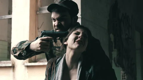 Kidnapping: a criminal manic kidnaps a young woman threatening her with a gun Stock Footage 49802990