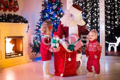 Kids and Santa opening Christmas presents Stock Photos
