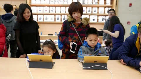 Kids are trying recreational Apps on iPad in the apple shop Stock Footage