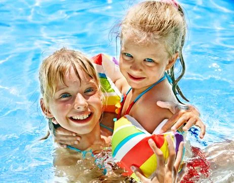 Kids with armbands in swimming pool. Stock Photos