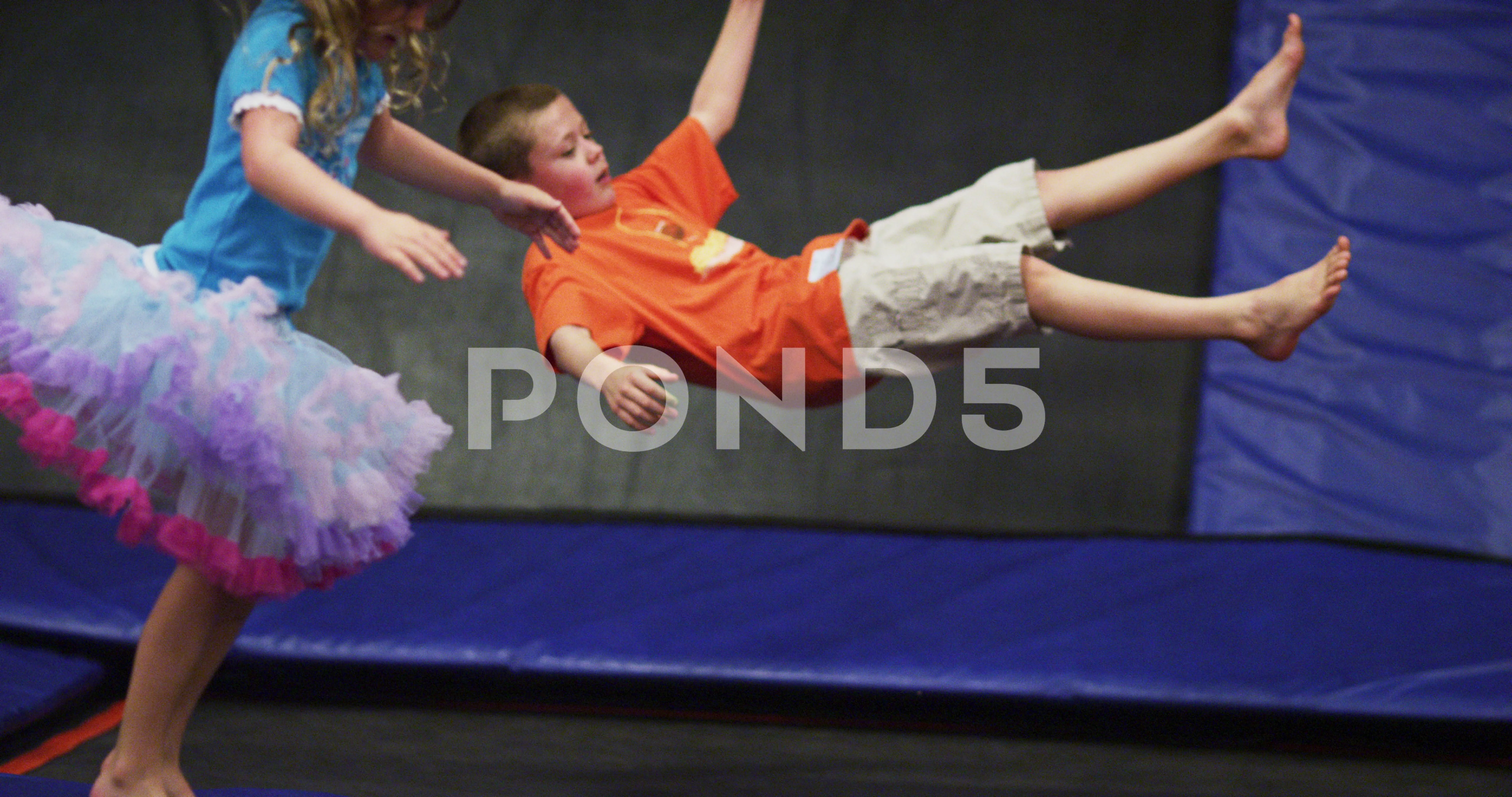 Scully Moske Ren kids bouncing on trampolines in slow mot... | Stock Video | Pond5