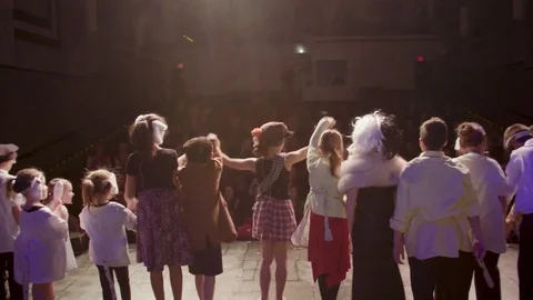 Kids bowing onstage after performance to applause Stock Footage 85286358