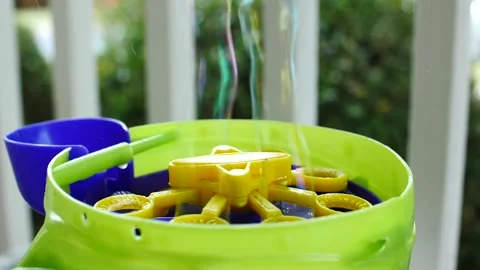 Kids bubble machine sending stream bubbles in the sky slow motion Stock Footage 207337692