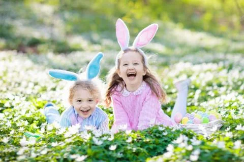 Kids with bunny ears on Easter egg hunt. Stock Photos