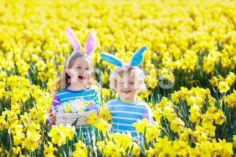 Kids with bunny ears on Easter egg hunt. Stock Photos