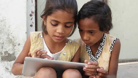 Kids busy working on a touch screen tablet and discussing, India Vídeo Stock 69875549