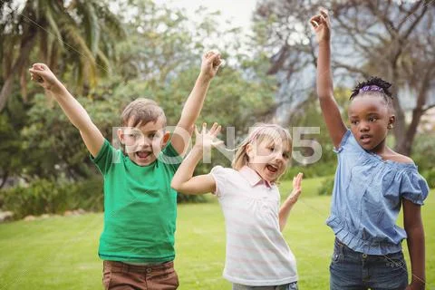 Kids celebrating with arms raised Stock Photos