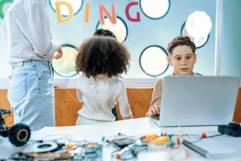 Kids in classroom learning about programming remote car with laptop. Erudition. 스톡 사진