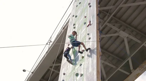 Kids climbing rock wall while climbing competition Stock Footage 65479343