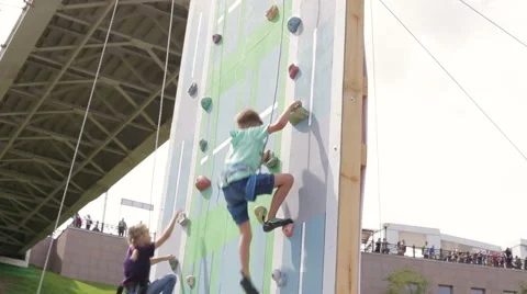 Kids climbing rock wall while climbing competition Stock Footage 65522944