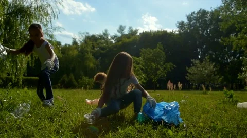 Kids collecting empty plastic bottle while cleaning outdoors Stock Footage 78019384