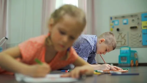 Kids Drawing while Lying on the Floor Indoors Stock Footage 129444090