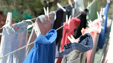 Kids dresses drying on clothes line during a sunny day,housekeeping family Stock Footage 219617124