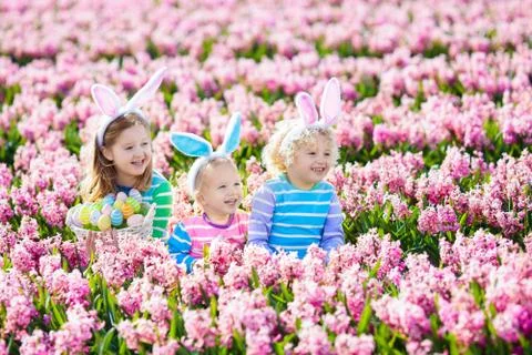 Kids on Easter egg hunt in blooming garden. Foto stock