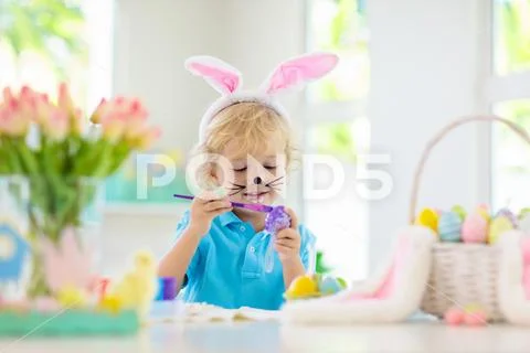 Kids on Easter egg hunt. Children dye eggs. Stock Photos