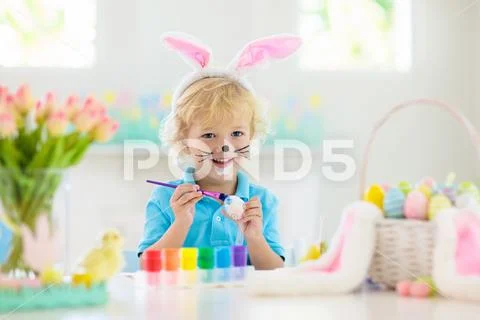 Kids on Easter egg hunt. Children dye eggs. Stock Photos
