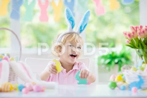 Kids on Easter egg hunt. Children dye eggs. Stock Photos