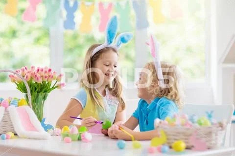 Kids on Easter egg hunt. Children dye eggs. Stock Photos