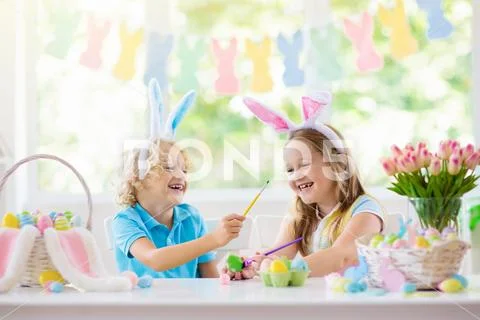 Kids on Easter egg hunt. Children dye eggs. Stock Photos