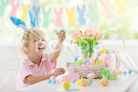 Kids on Easter egg hunt. Children dye eggs. Stock Photos