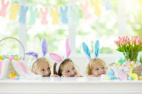 Kids on Easter egg hunt. Children dye eggs. Stock Photos