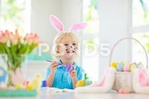 Kids on Easter egg hunt. Children dye eggs. Stock Photos