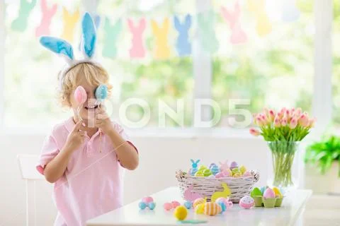 Kids on Easter egg hunt. Children dye eggs. Stock Photos