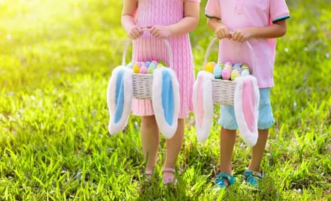 Kids with eggs basket on Easter egg hunt. Stock Photos