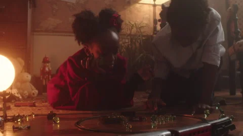 Kids enjoy a fun game of marbles on the floor in a cozy living room Stock Footage 319907462