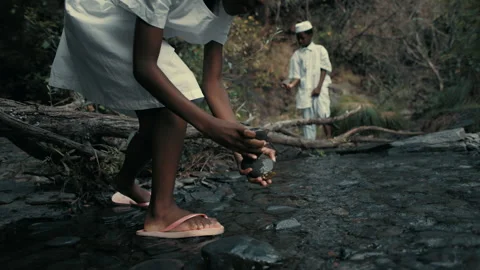 Kids exploring a stream while wearing Stones Pebbles dress in nature Stock Footage 319905812