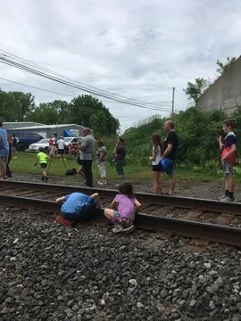 Kids feeling vibrations from train on railroad tracks Stock Photos