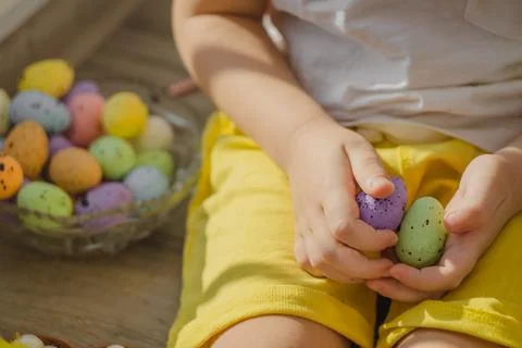Kids hands with easter eggs with brush in different colors. Close up view. Stock Photos