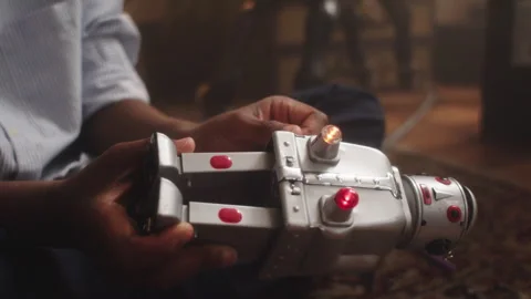 Kid's hands explore fun with toy robot on a cozy living room floor Vídeos de archivo 319911706