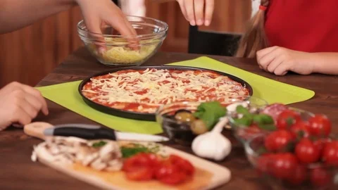 Kids hands making a pizza putting on the grated cheese Stock Footage 80252475