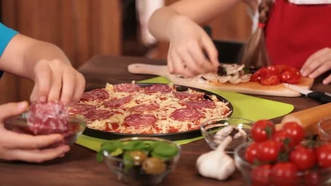 Kids hands making a pizza putting on the various topping - closeup Stock Footage 80252517